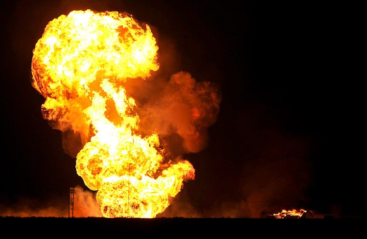 Flames blazed more than 400 feet high above a natural gas line explosion that rocked Bushland, Texas about 1 a.m. Thursday Nov. 5, 2009 in the Texas Panhandle. The roaring sound of the leaking gas could be heard and seen from Amarillo more than 10 miles away. The gas line explosion was located about 2 miles north of Interstate 40 and 1 mile east of Bushland Road. A nearby structure is seen burning on the right of the photo and a high power utility pole is seen smoldering to the left of the blaze. A nearby rural neighborhood was evacuated by Potter County Sheriffs. (AP Photo/Michael Schumacher - Amarillo Globe News)