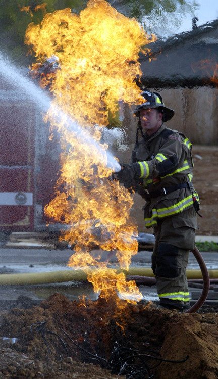 Monday November 12 2007 in Chico, CA. On Glenshire near Mariposa a home under construction had it's gas line catch on fire.City of Chico Firefighter Wes Metroka stood by with a firehose protecting a near by home until PG&E could shut off the gas. . in this picture, (Ty Barbour/Chico Enterprise-Record)